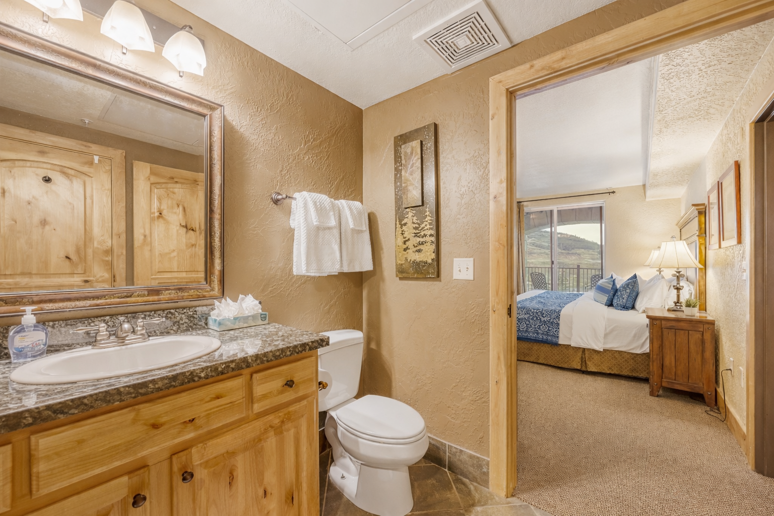 Enjoy this mountain-style bathroom featuring granite countertops, rustic wood cabinetry, and a clean, modern finish—conveniently located just steps from the cozy master bedroom.