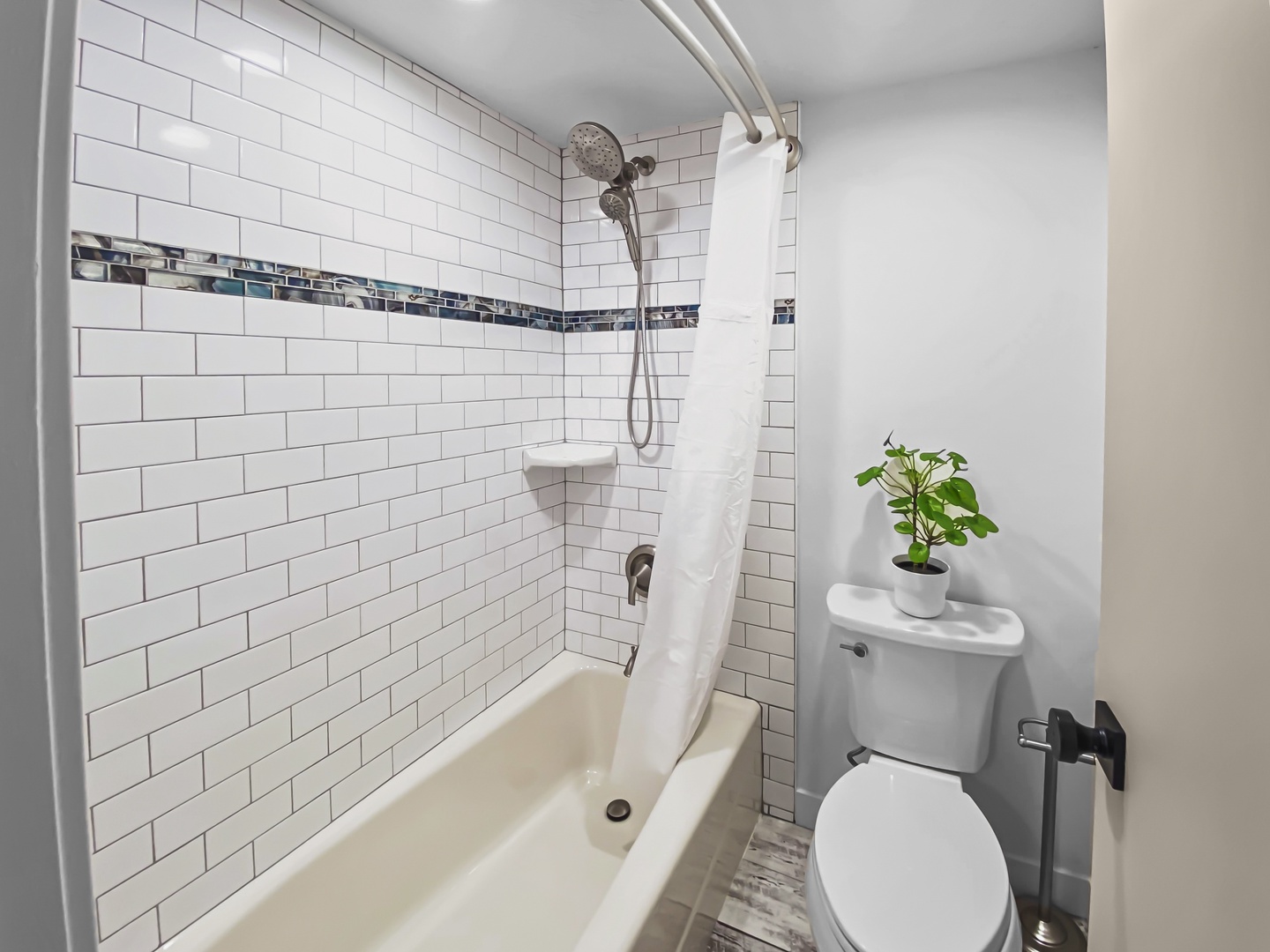 Your private bathroom features classic subway tile with accent details, a tub-shower combo, and a touch of greenery to make you feel right at home.