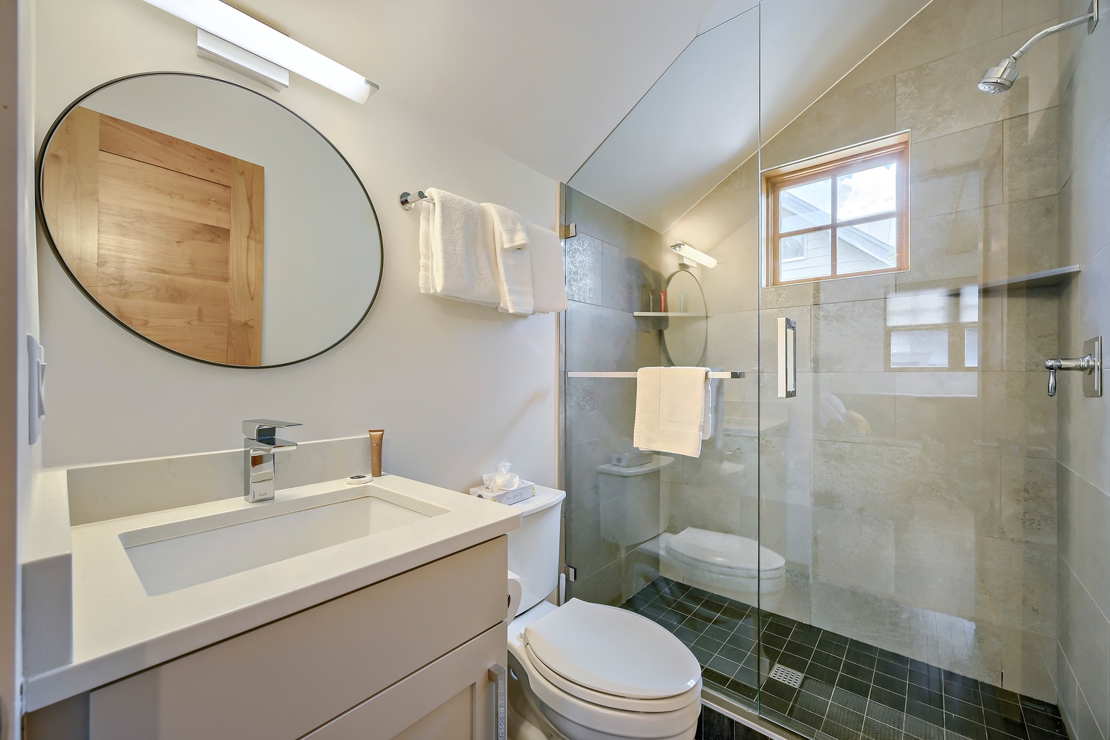 Step into your private retreat with elegant marble tile, a spacious walk-in shower, and natural light that makes every morning feel refreshing.