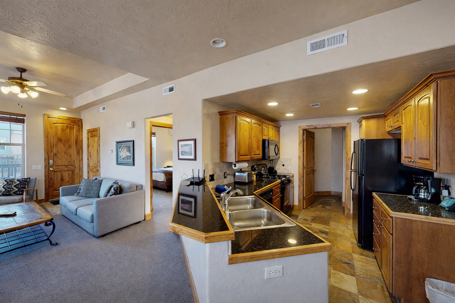 Your spacious suite features a full kitchen with granite counters and modern appliances, seamlessly flowing into a comfortable living area.