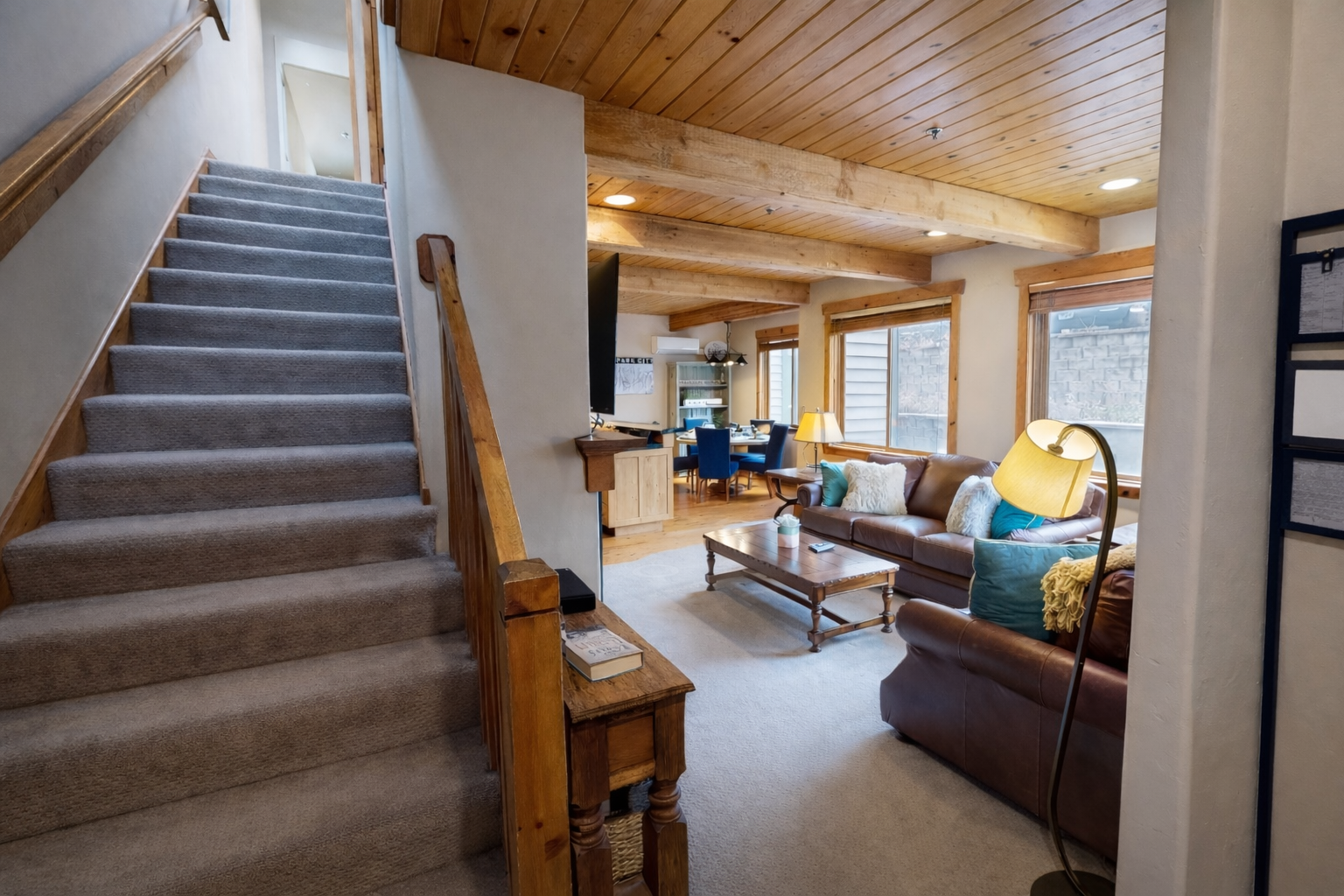 Unwind in this cozy mountain living room featuring a plush leather sofa and natural wood beams.