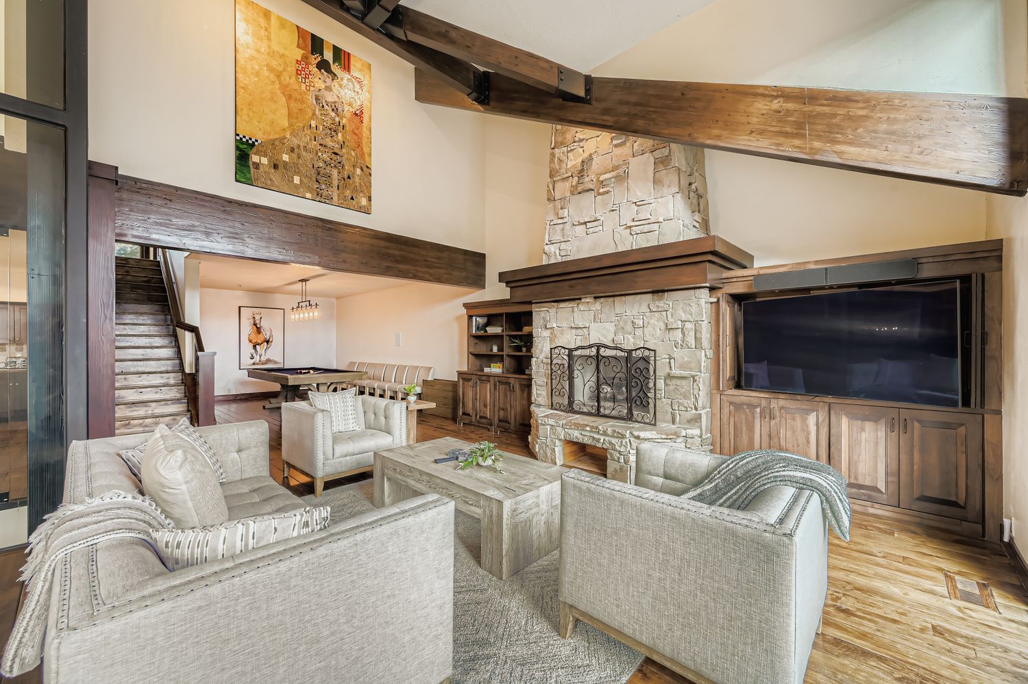 Relax in your spacious living room featuring rustic wood beams, a cozy stone fireplace, and comfortable seating perfect for unwinding after your adventures.
