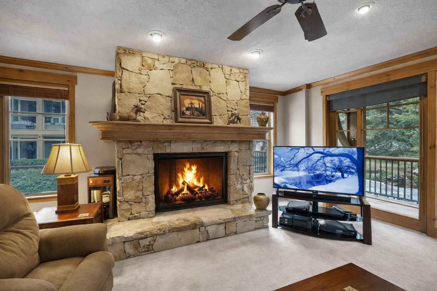 Cozy living room perfect for relaxing after the slopes. Enjoy the warm stone fireplace, comfy seating, and TV. A true mountain retreat.