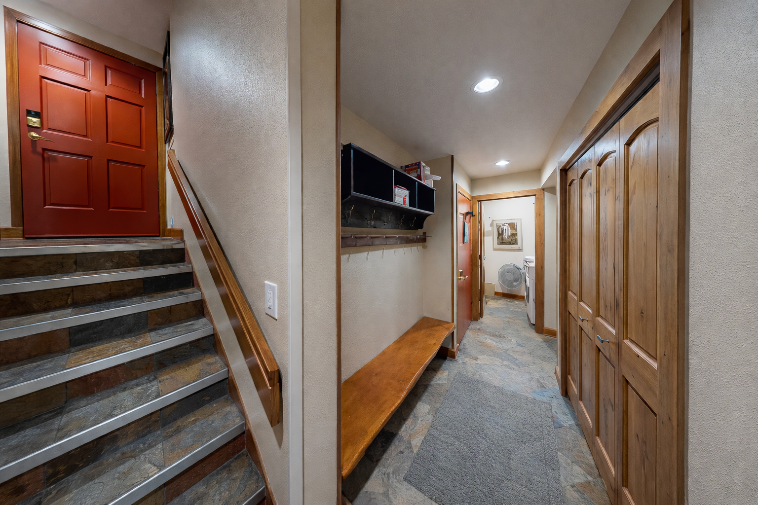 Welcome to this cozy mountain retreat! This inviting entryway features a rustic wooden bench and ample closet space for all your gear.