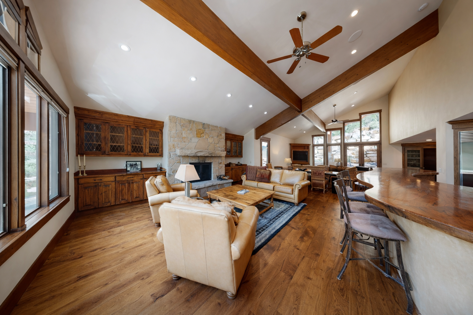Relax in our spacious living area with a vaulted wood ceiling, cozy fireplace, and stunning views of the surrounding nature.