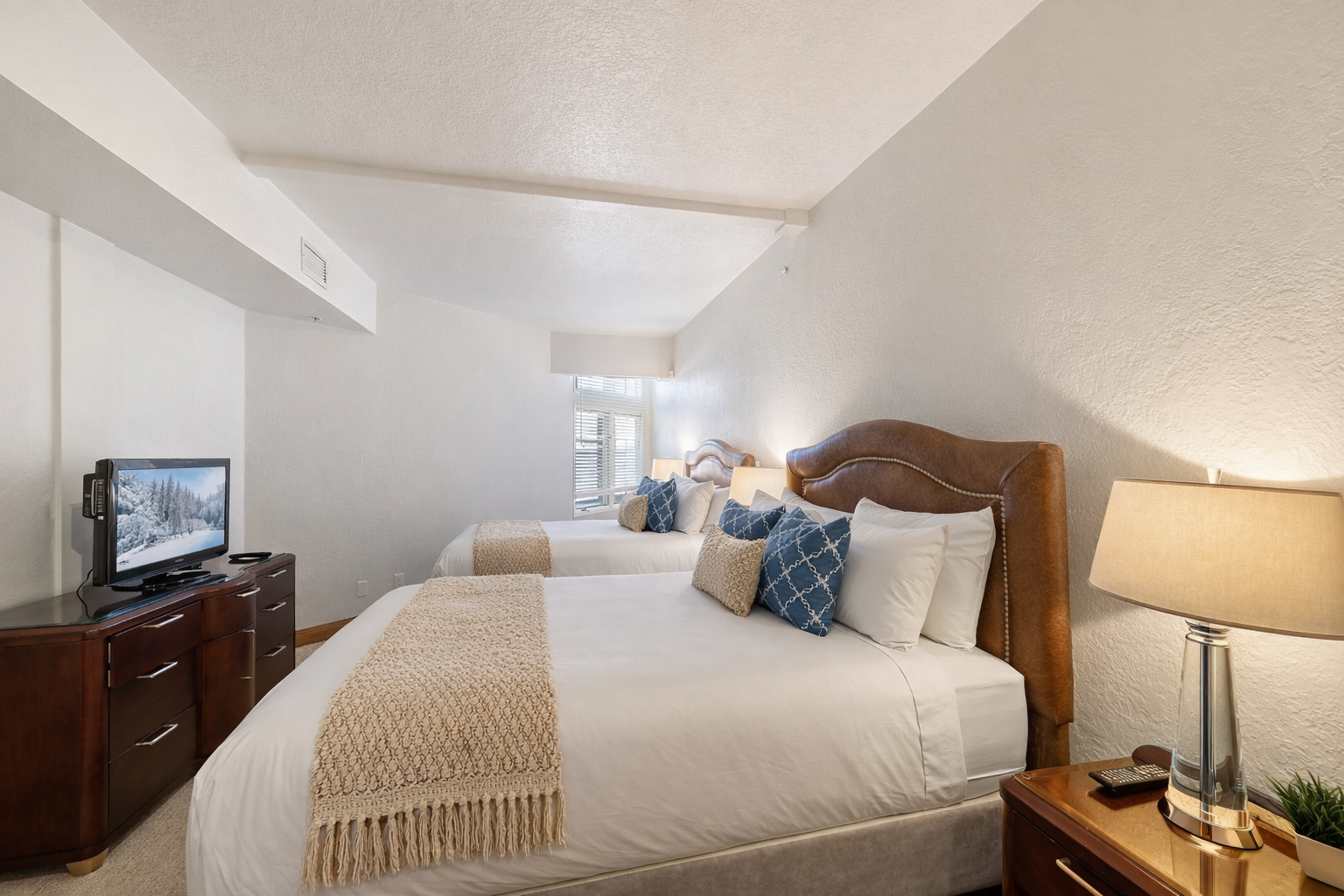 Sink into crisp linens and plush pillows in your serene bedroom retreat, where warm lighting and thoughtful touches create the perfect atmosphere for rest.