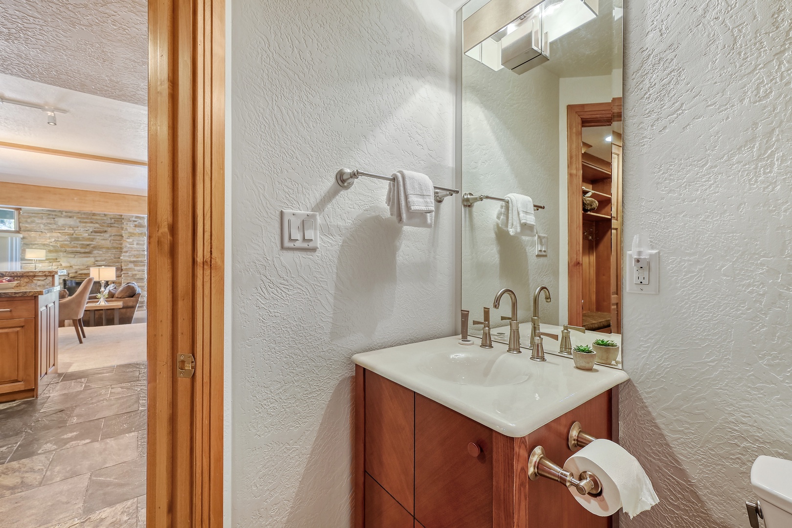 Step into your private bathroom featuring warm wood vanity, modern fixtures, and thoughtful touches that create a spa-like retreat.