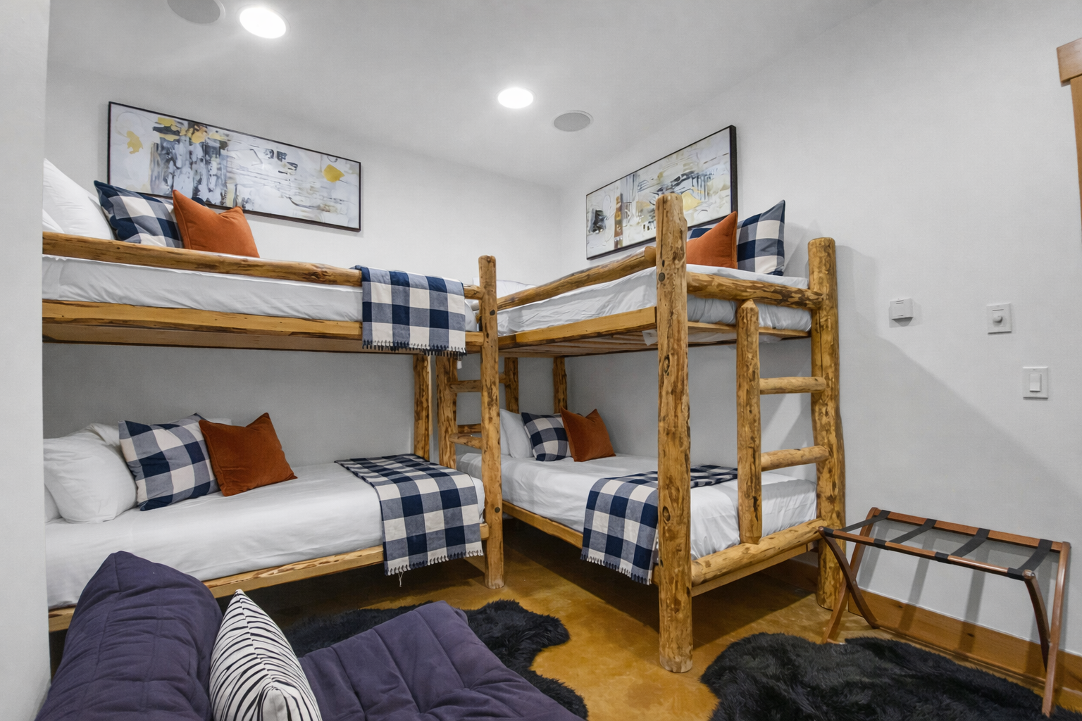 Your cozy bunk room features rustic wooden beds with plaid bedding, perfect for families or groups sharing memories together.
