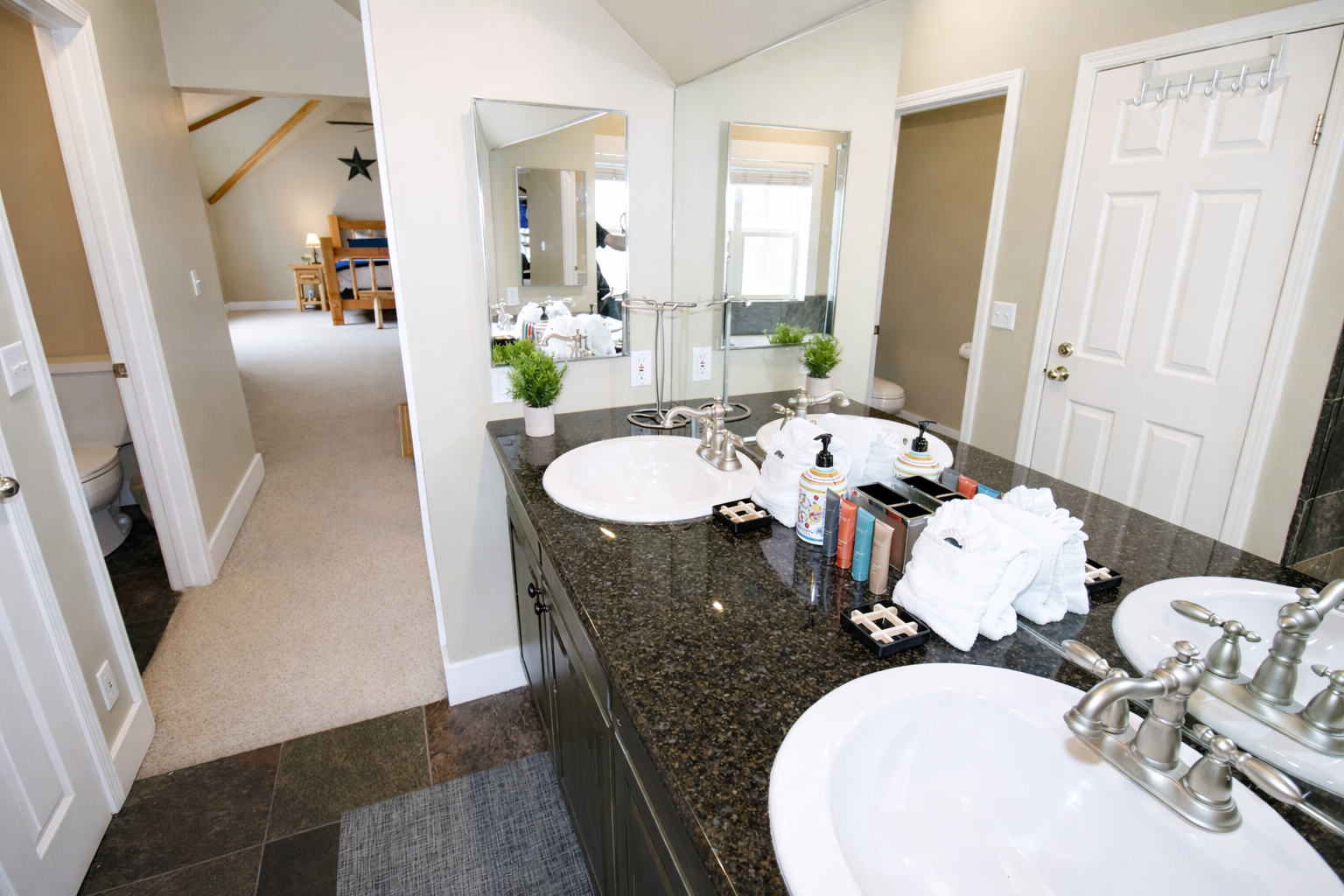 Indulge in the spa-like master bathroom, featuring a double vanity with dark granite countertops and a large jetted soaking tub. It's the perfect place to recharge after a day of adventure.