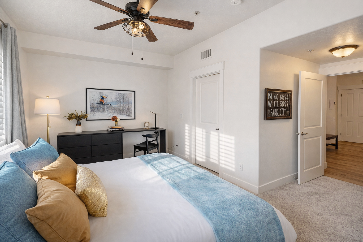 Relax in this bright, modern bedroom featuring a plush king-size bed, sleek dark wood furniture, and a large flat-screen TV. A serene mountain retreat for your next Park City adventure.