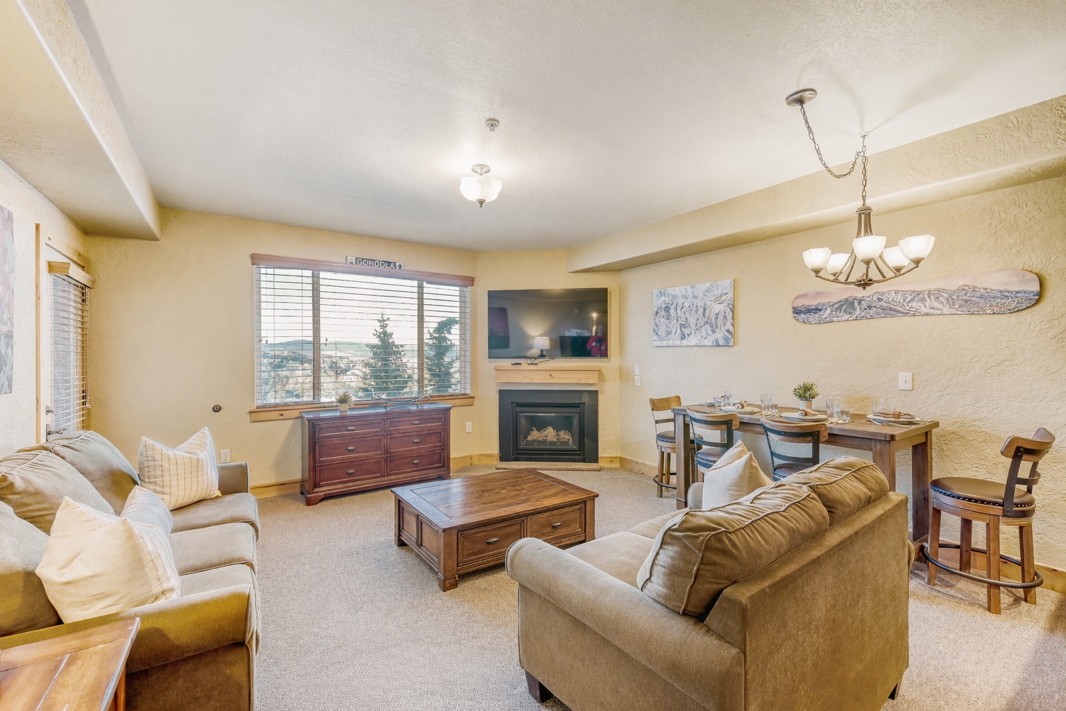 Unwind in your spacious living area with plush seating, warm fireplace, and mountain views from large windows.