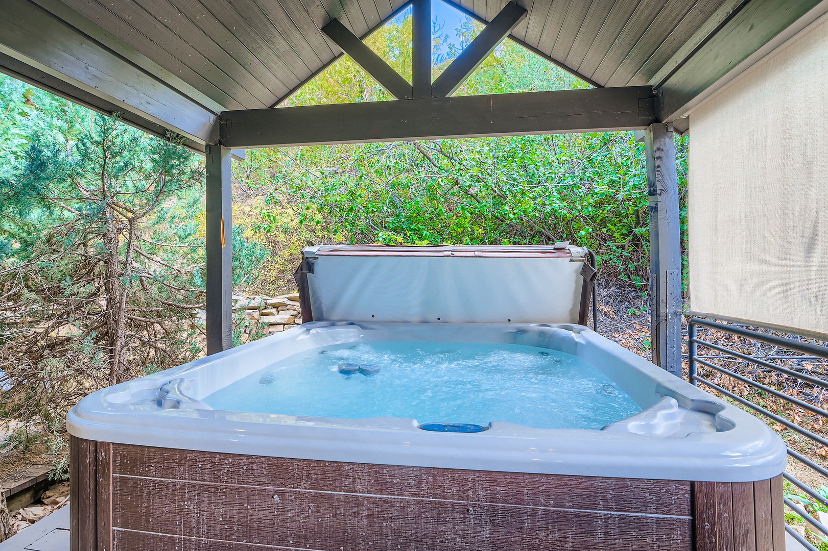 Slip into your private hot tub surrounded by lush greenery—your own secluded oasis under the pines awaits.