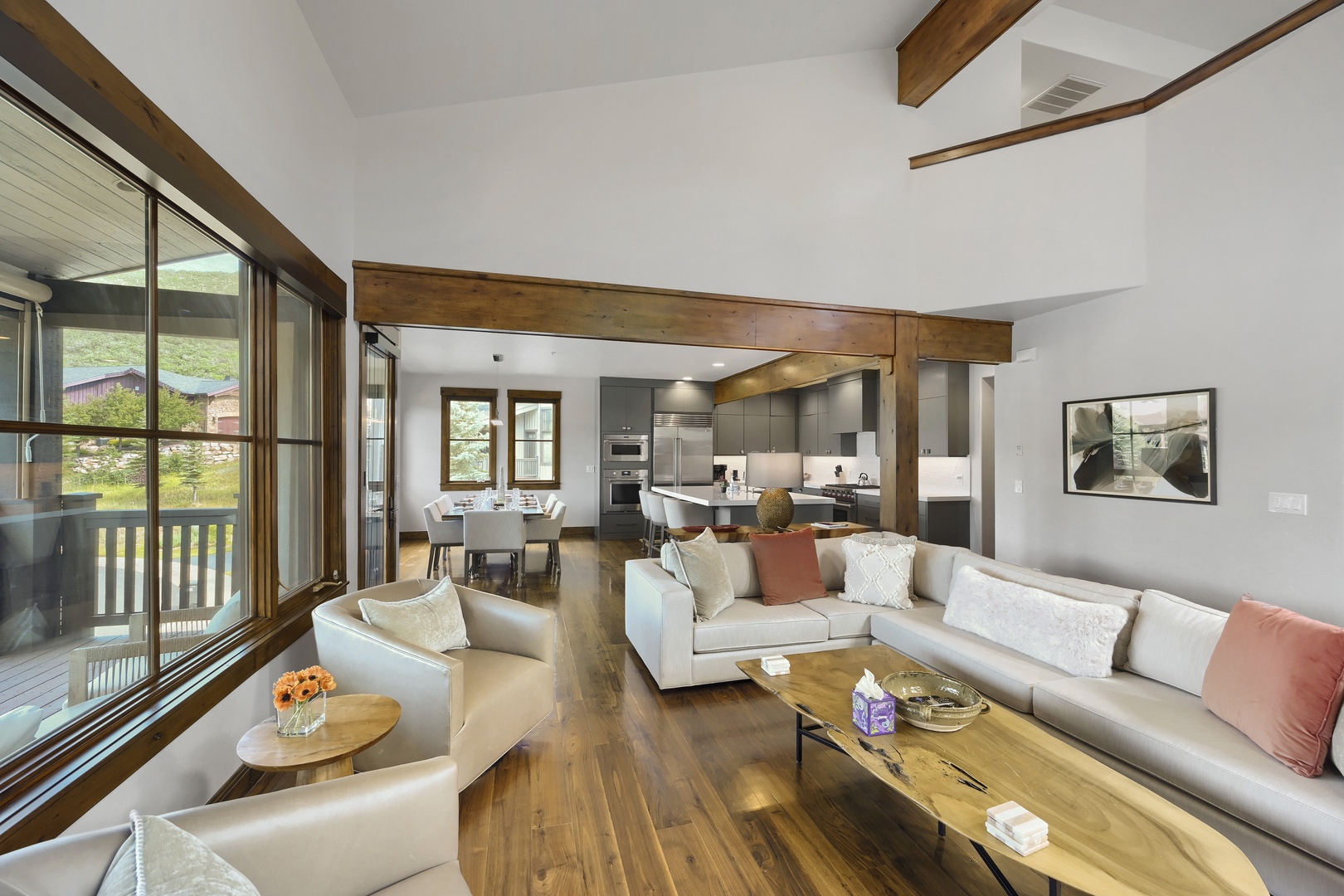 Sink into plush seating and soak in mountain views through expansive windows—your home away from home blends modern elegance with warm wood accents.