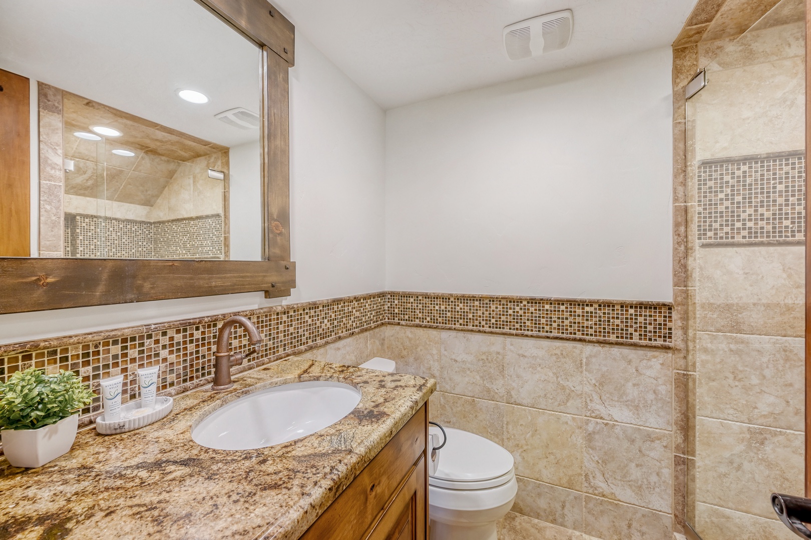 Unwind in your private bathroom featuring elegant travertine tiles, granite countertops, and beautiful mosaic accents that create a spa-like retreat.