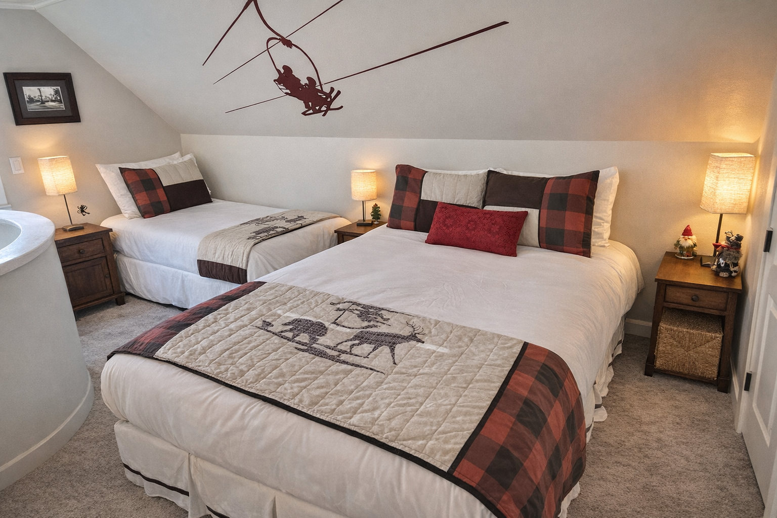 Cozy mountain-themed bedroom with two comfortable beds featuring rustic wildlife quilts and plaid accents.