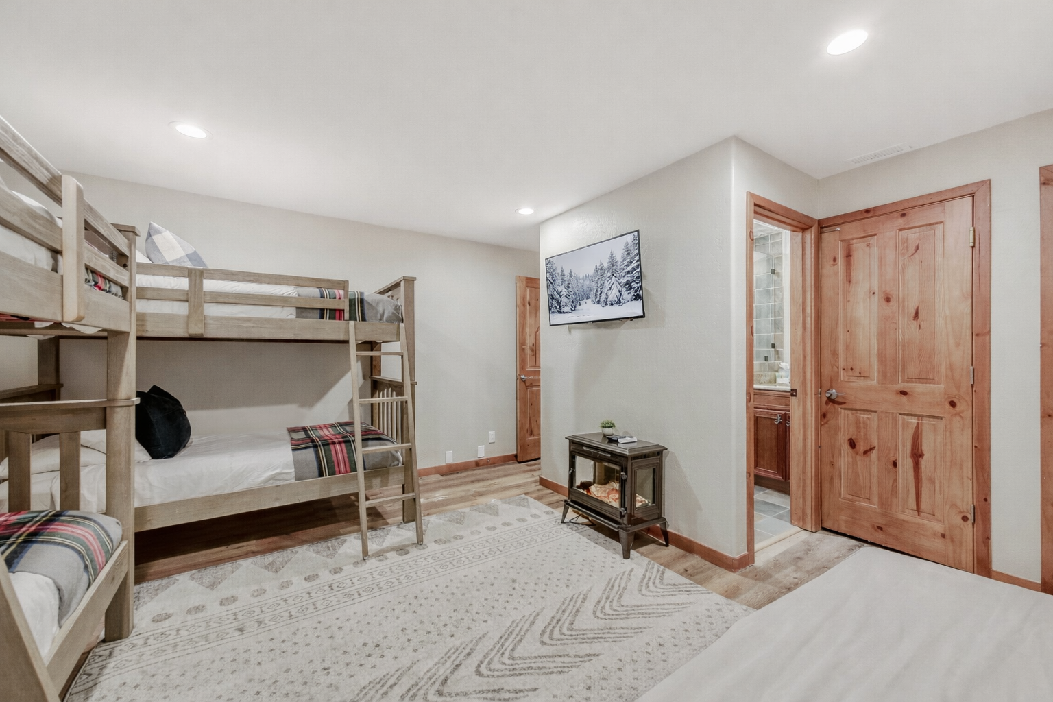 Two sturdy wooden bunk beds create a fun sleeping space where kids can make memories together in this bright, cheerful room.