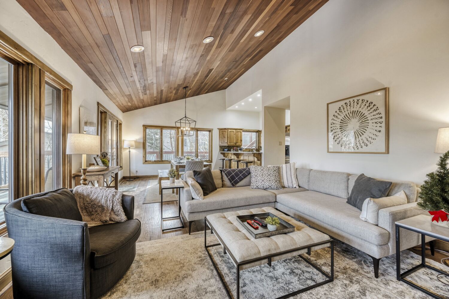 Sink into plush seating beneath stunning wood-planked ceilings, where natural light streams through large windows into your elegant retreat.