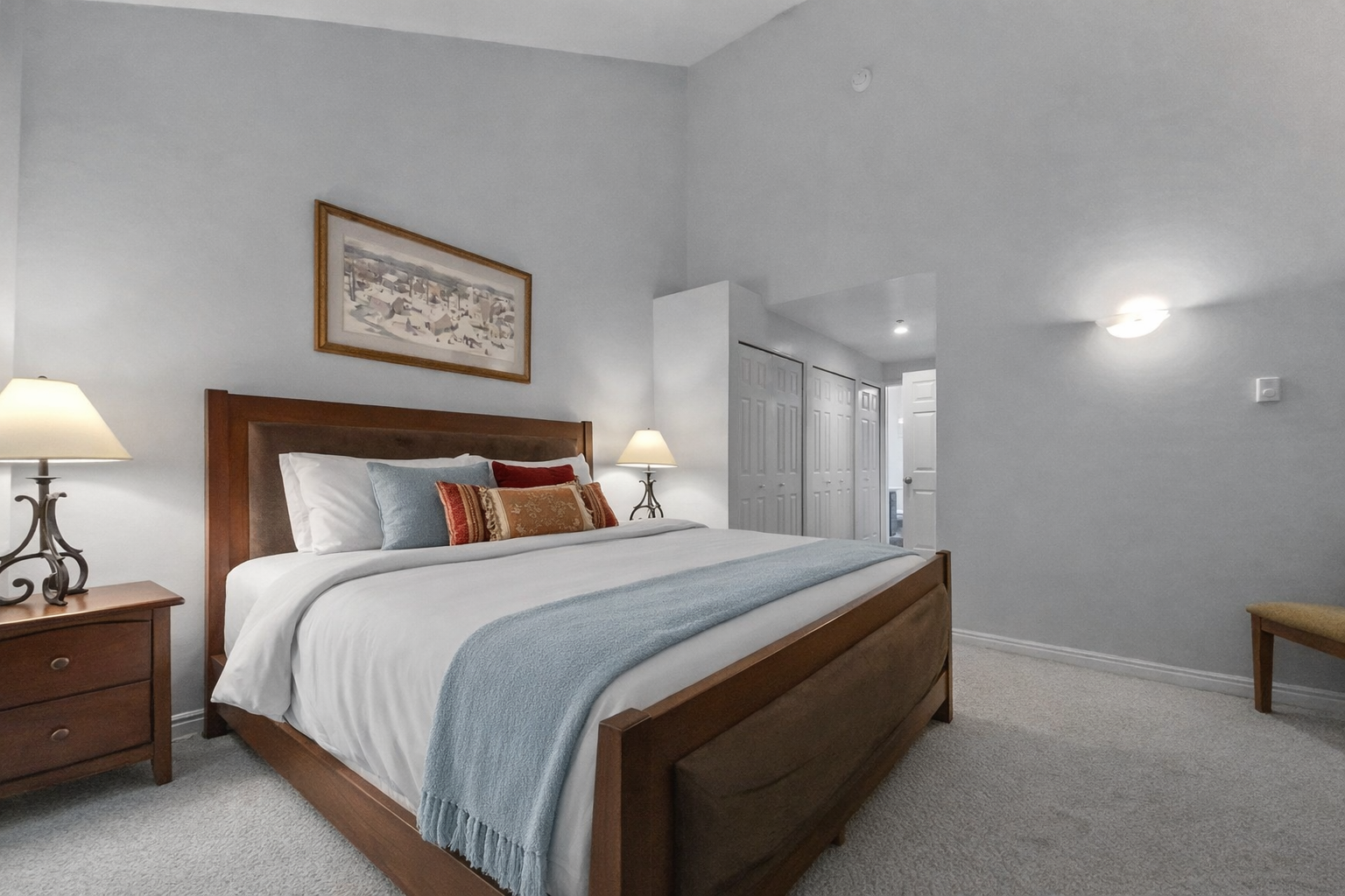 Peaceful guest bedroom featuring a comfortable bed, ceiling fan, and lovely artwork. A tranquil retreat for a restful stay in the mountains.