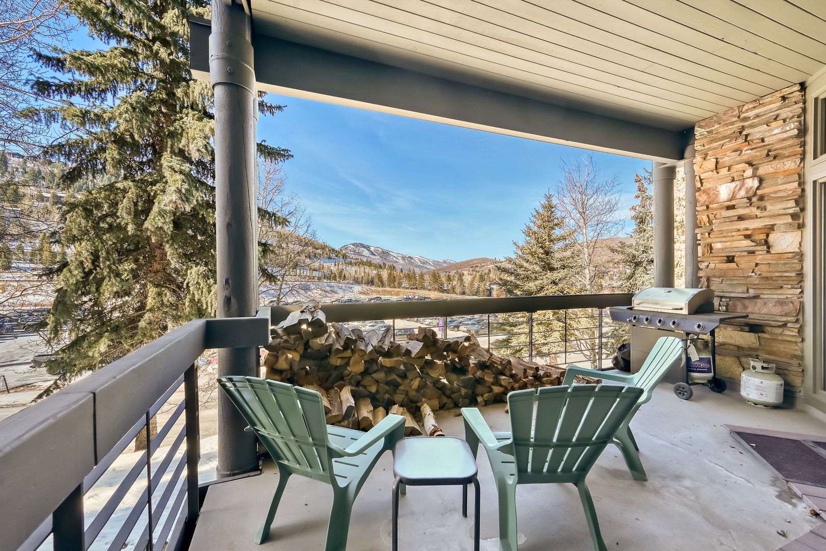 This covered patio offers mountain views, a grill for cooking, and cozy seating for two—perfect for sipping morning coffee or watching the sunset over the snowy peaks.