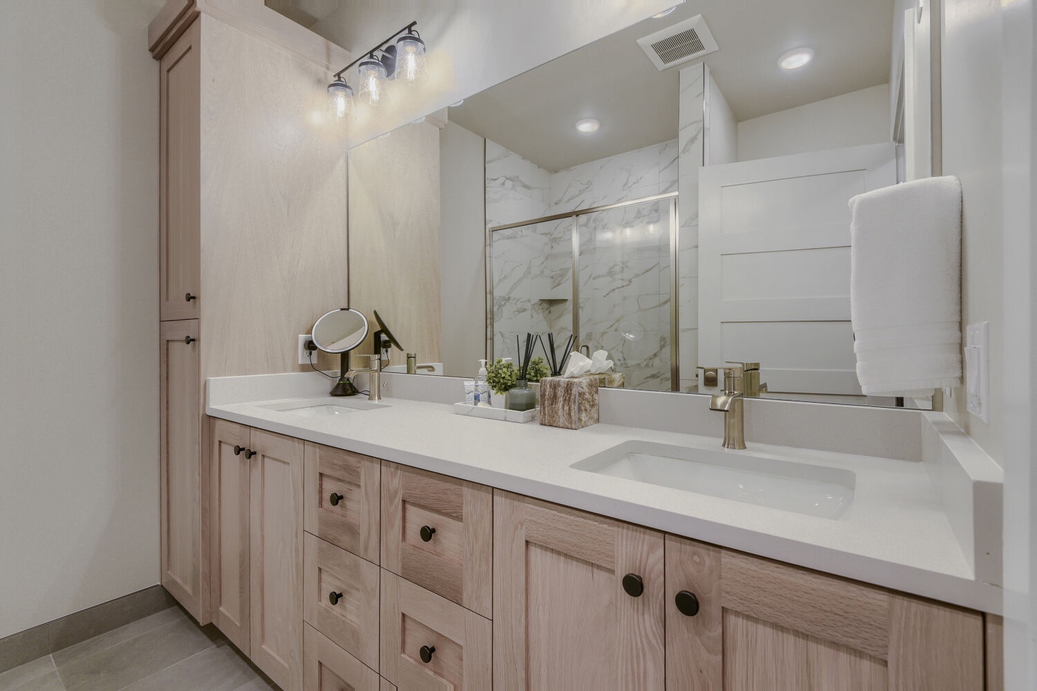 Unwind in your spa-inspired bathroom, where warm wood tones meet sleek marble and soft lighting creates the perfect retreat for your morning routine or evening relaxation.