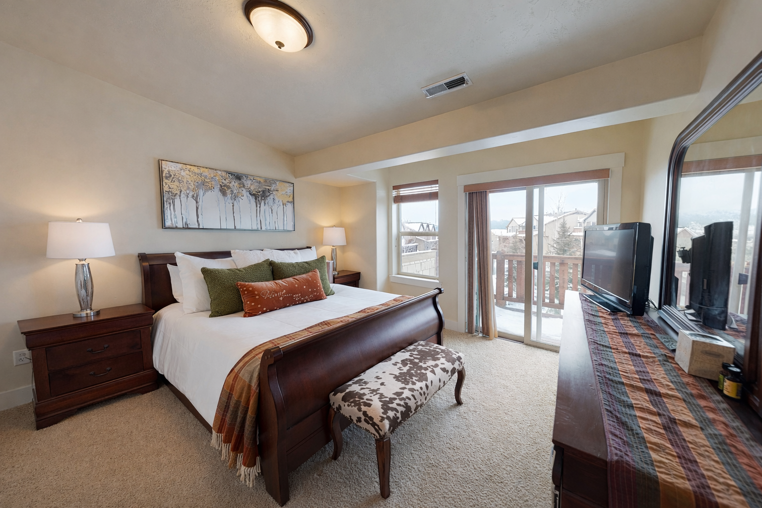 Sink into your plush king bed with mountain views streaming through the balcony doors. Warm wood furnishings create a cozy retreat after adventure-filled days.