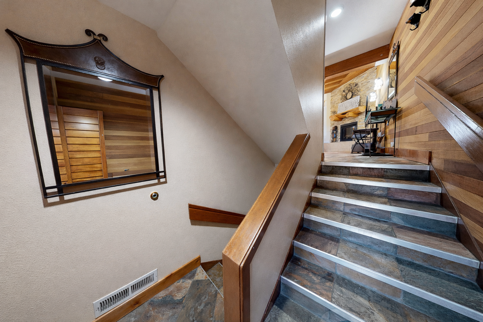 Your cozy retreat awaits upstairs with warm wood accents and natural stone steps guiding you to relaxation.