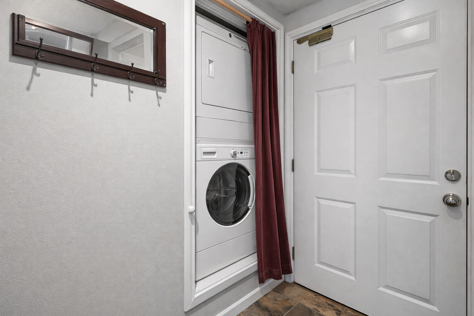 Modern in-unit laundry with a sleek stacked washer and dryer unit. Perfect for keeping your gear fresh during your stay.