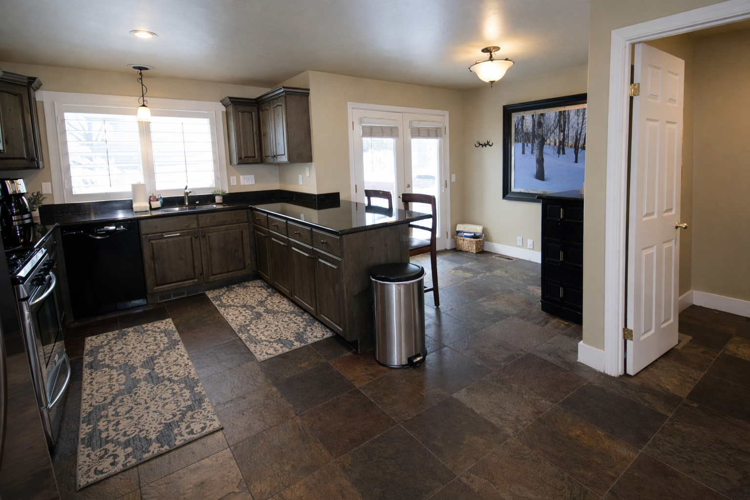 Your fully equipped kitchen features dark granite countertops, stainless steel appliances, and a cozy fireplace for memorable meal preparation and gathering.