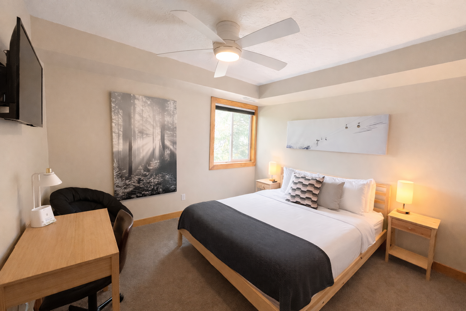 Cozy guest bedroom with a comfortable bed, ceiling fan, and desk. Perfect for a restful stay in Park City.