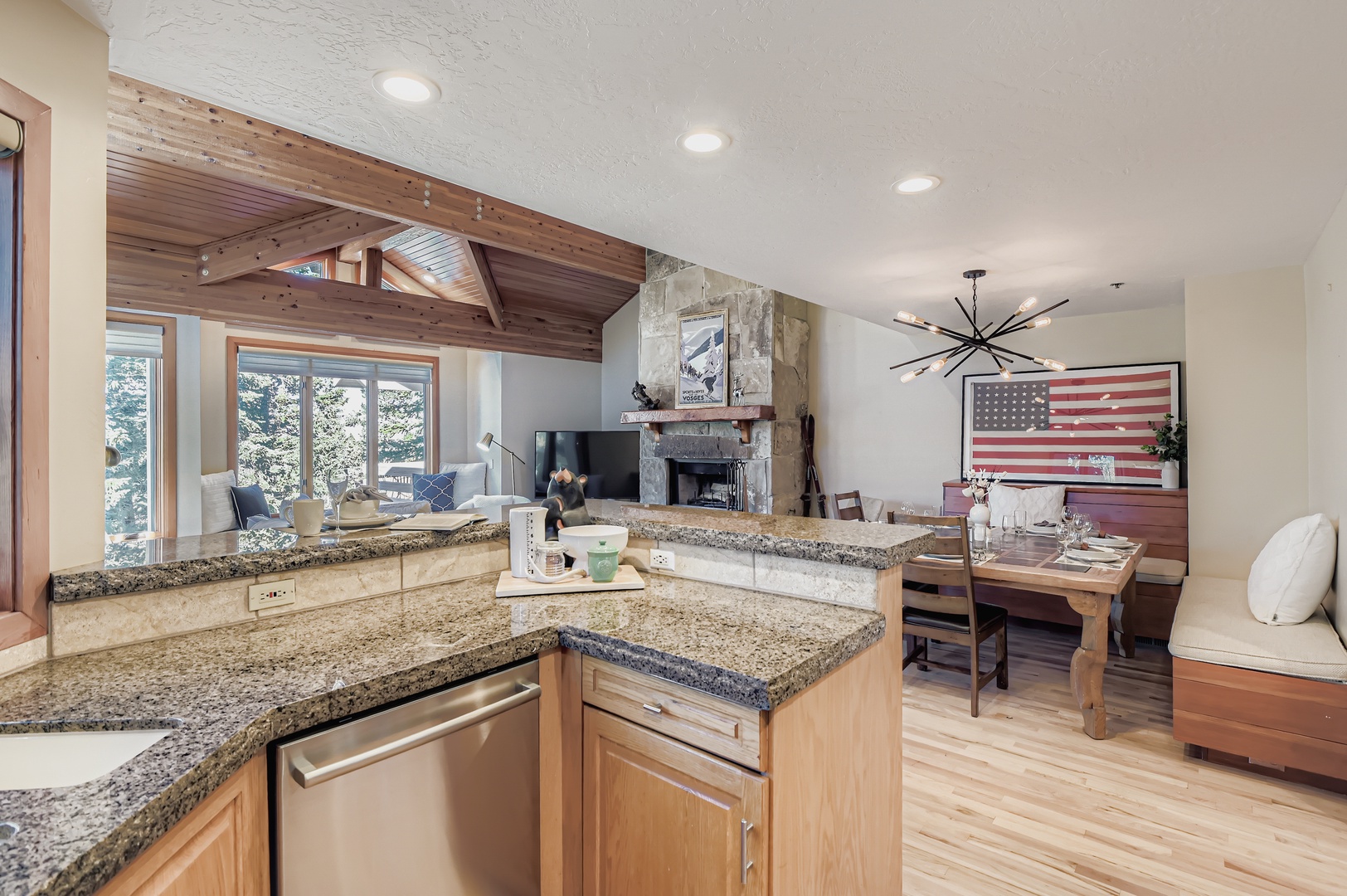 Open-concept kitchen flows into living and dining areas with granite countertops, wood finishes, and a stone fireplace—the perfect retreat after mountain adventures.