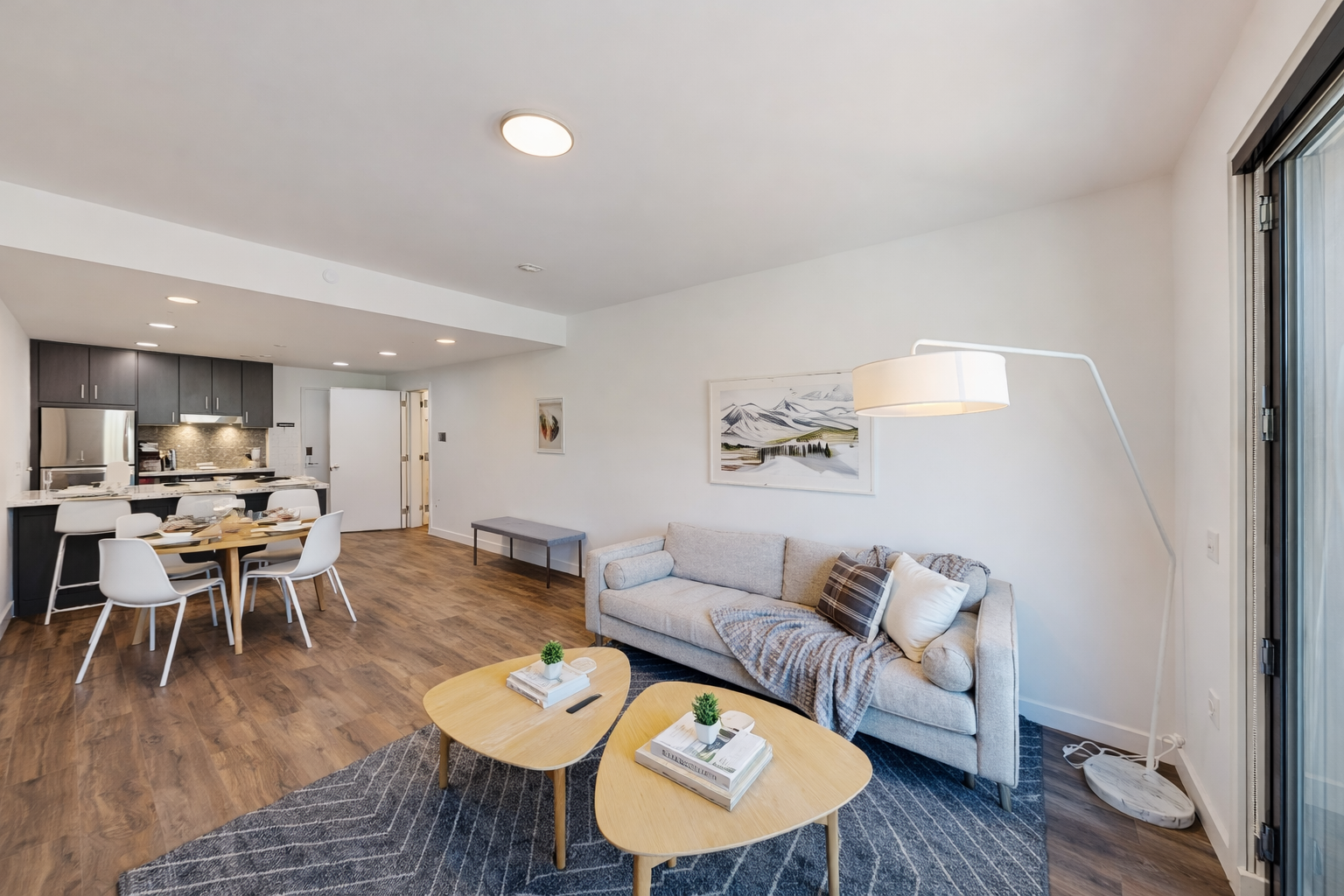 Relax in your stylish living space where modern comfort meets sleek design, featuring cozy seating and an open kitchen perfect for memorable meals.