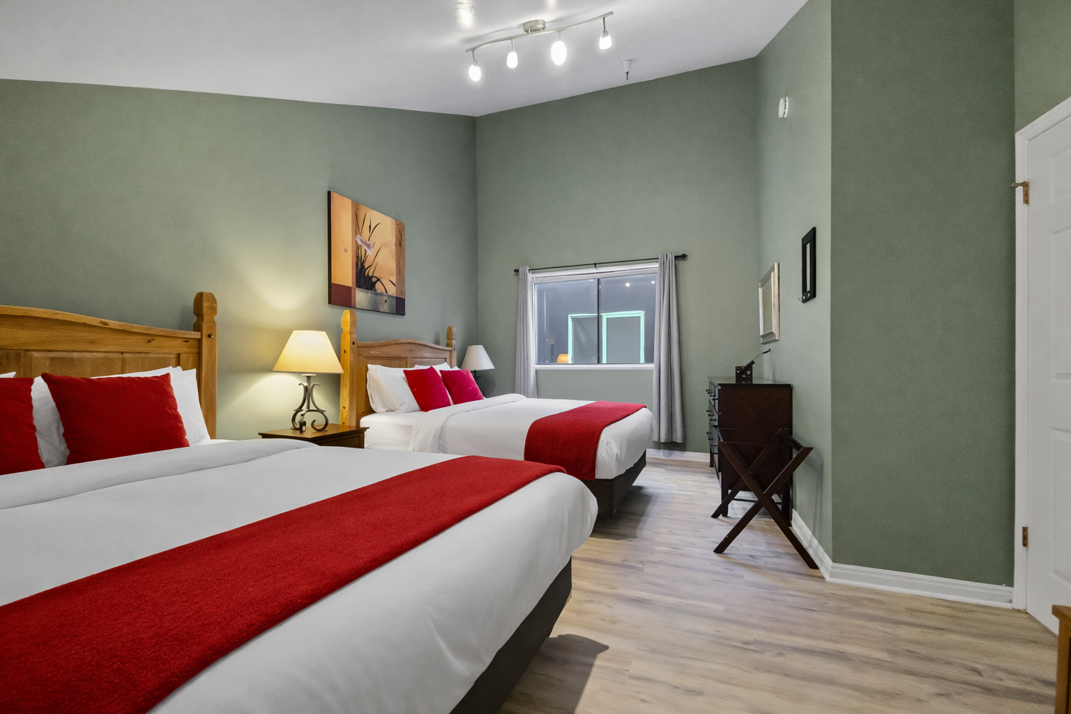 Comfortable & modern double room with stylish red accents, wood flooring, and large windows. A relaxing space for your Park City stay.