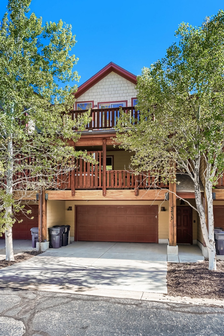 A charming multi-level mountain retreat framed by aspens, featuring spacious balconies and convenient garage parking for easy arrival.