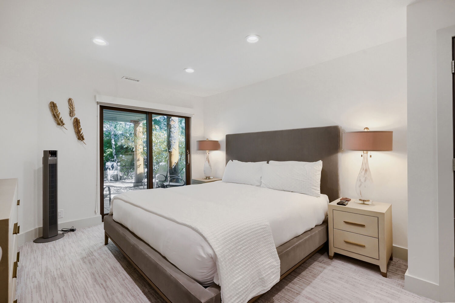 Sink into crisp white linens and let the soft glow of bedside lamps ease you into vacation mode, with a peaceful garden view just beyond your door.