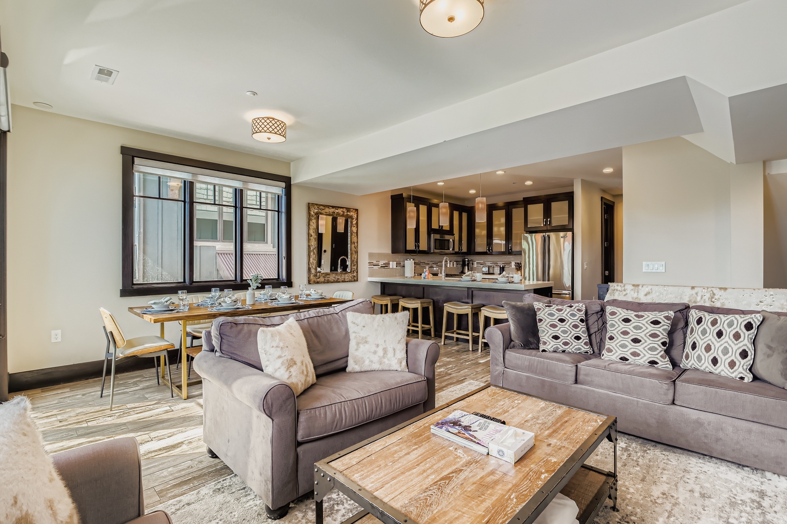 Relax in your bright, open living space where natural light pours through large windows and connects to a fully equipped modern kitchen—perfect for cooking, gathering, and making memories during your stay.