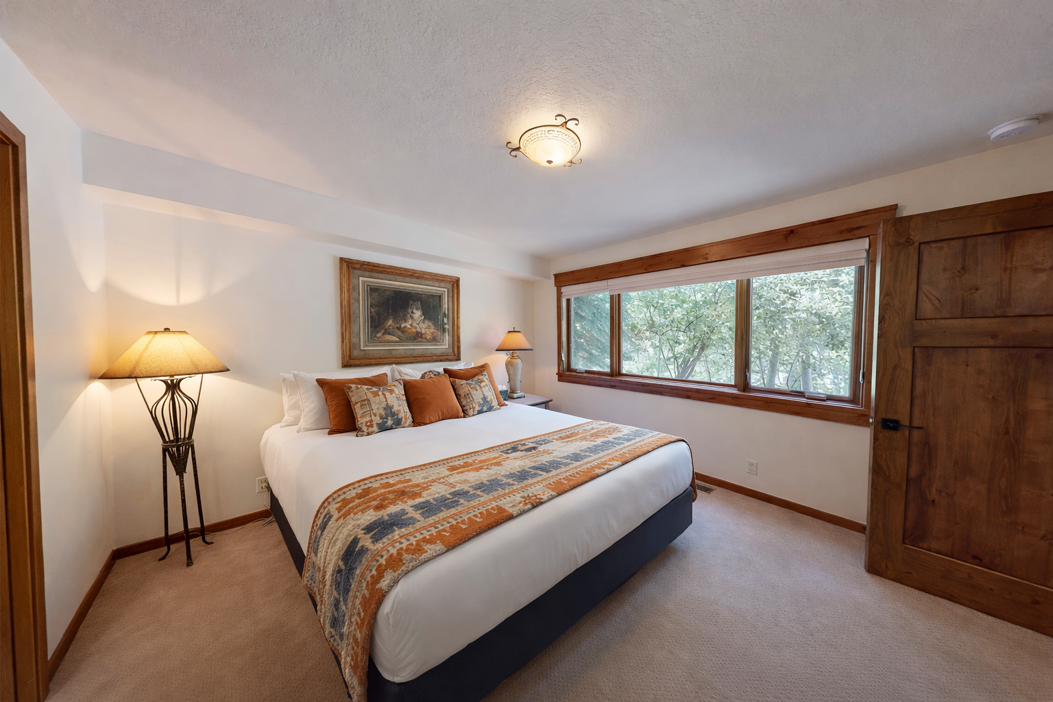 Sink into crisp linens and plush pillows in your tranquil bedroom retreat, where elegant artwork and warm lighting create the perfect atmosphere for restful nights.