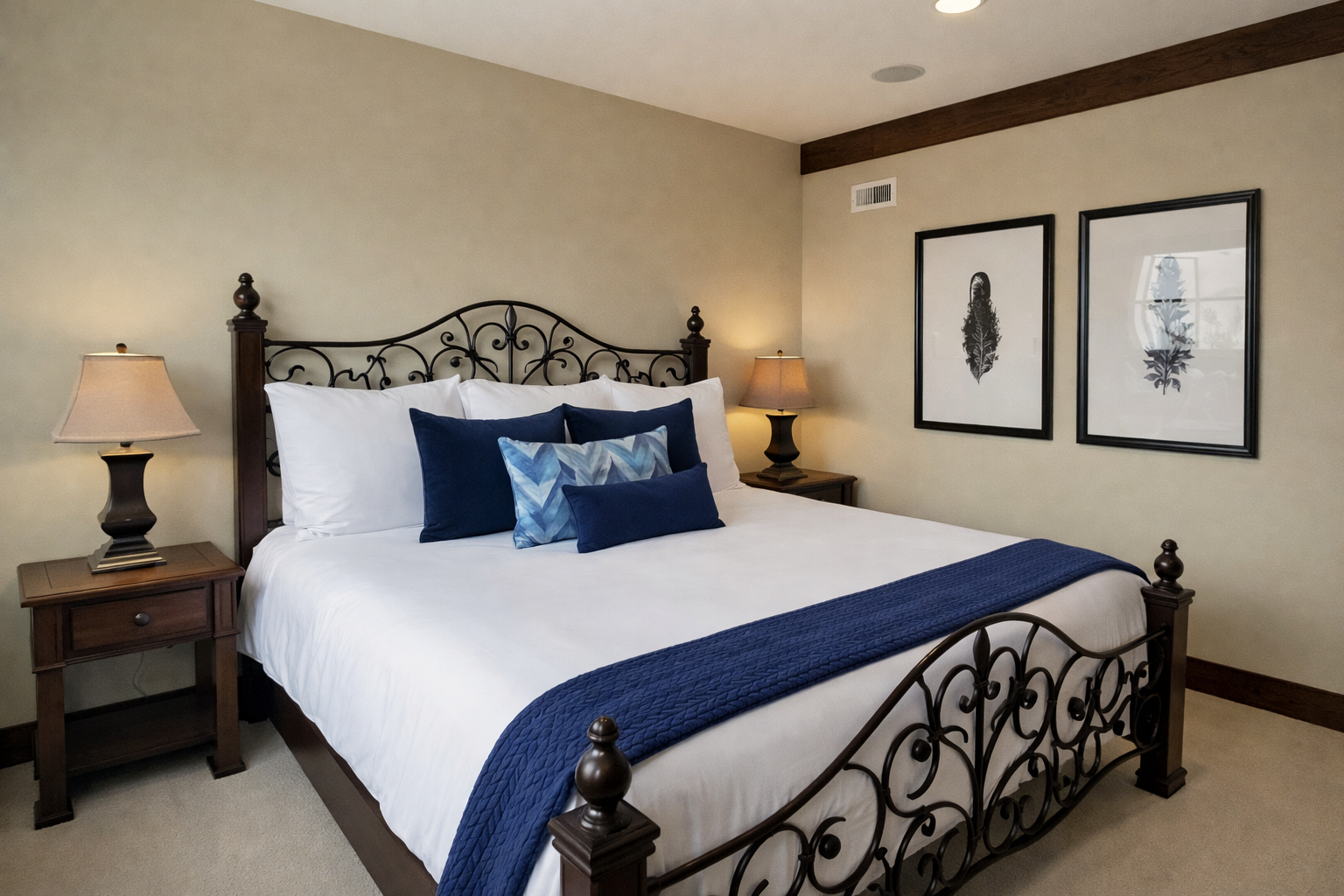 Sink into crisp white linens and navy accents in your elegant bedroom, where wrought iron details and warm lighting create the perfect retreat.
