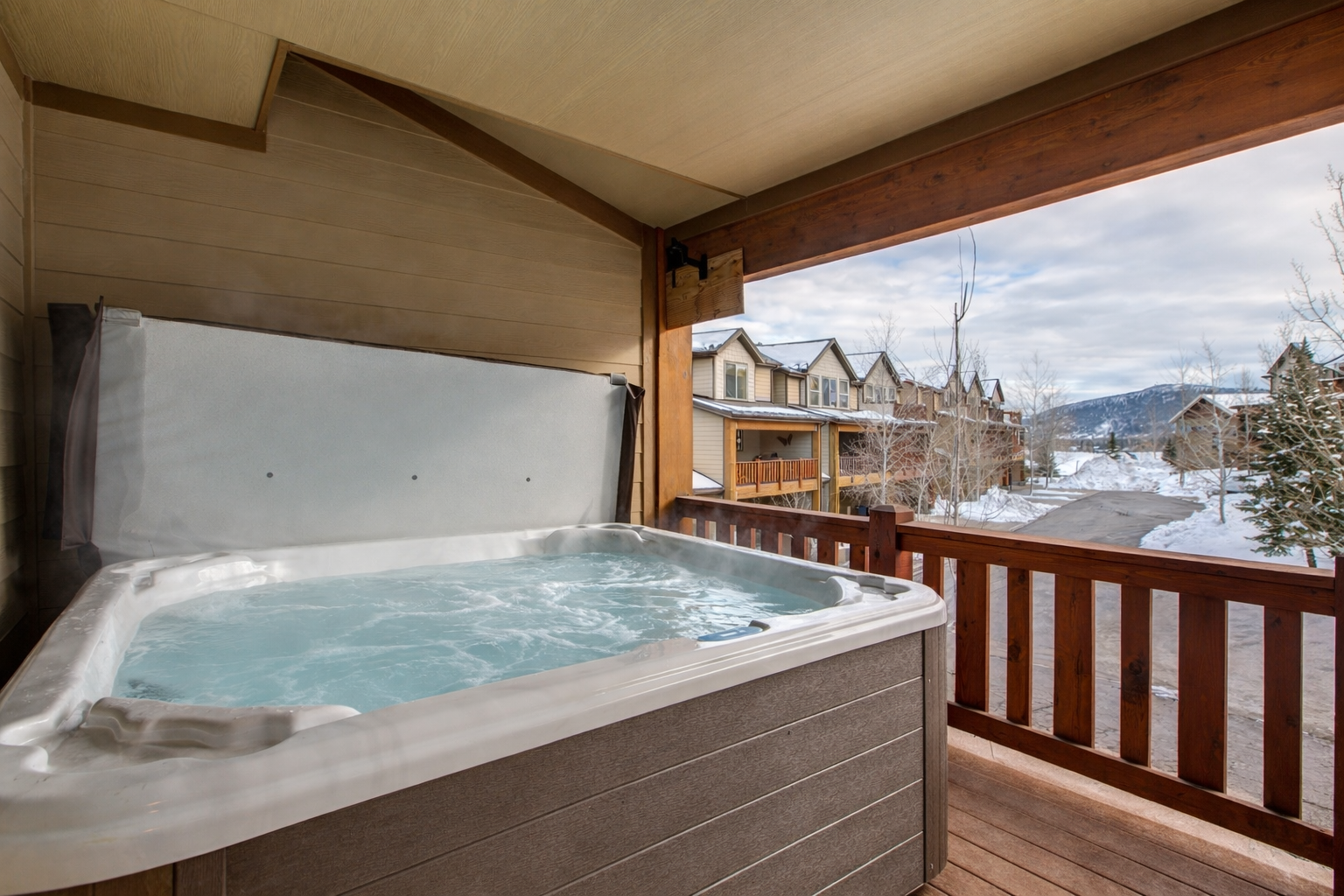 Unwind in your private hot tub while soaking up stunning winter mountain views from your covered deck.
