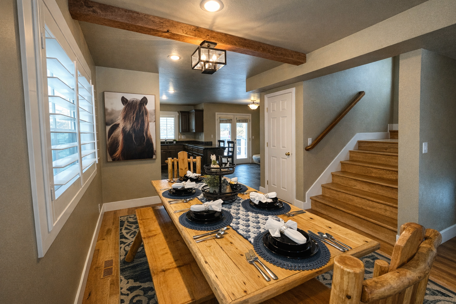 Gather around this rustic wooden dining table, featuring a mix of high-back chairs and bench seating. The space is beautifully accented with mountain-inspired decor, a patterned area rug, and soft overhead lighting.