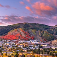 Stunning aerial perspective of the colorful autumn landscape surrounding the area, with vibrant fall foliage painting the mountainsides in brilliant reds and oranges.
