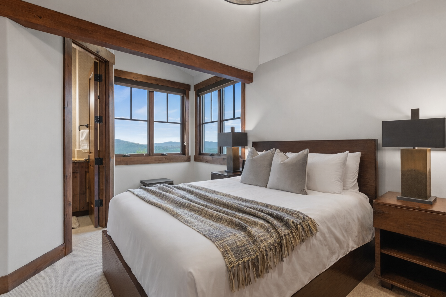 Retreat to the charming upstairs queen suite featuring a cozy bed, stunning mountain views, and a private ensuite bathroom.