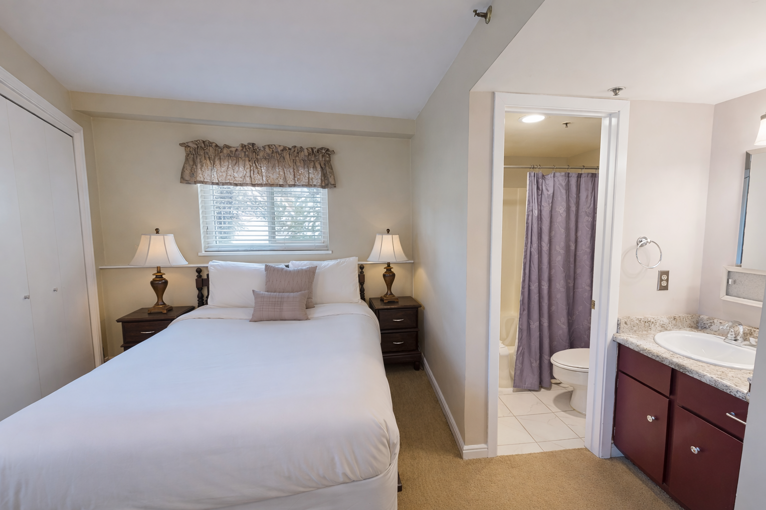 Cozy mountain retreat! Relax in this inviting king room with warm lighting, wood furniture, and an ensuite bath.