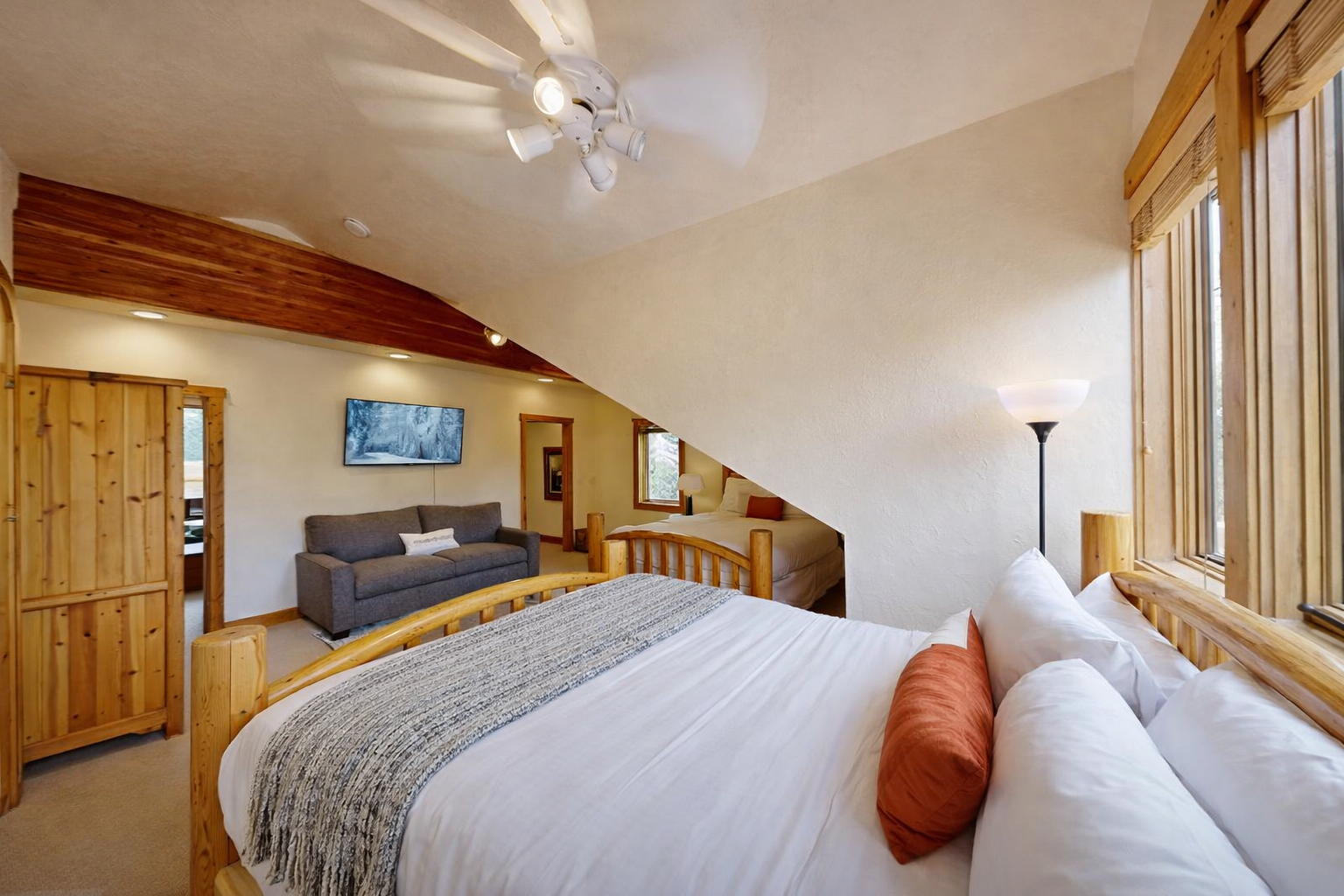 Relax in your cozy twin bedroom with warm wood accents, exposed beams, and comfortable seating for ultimate mountain lodge comfort.