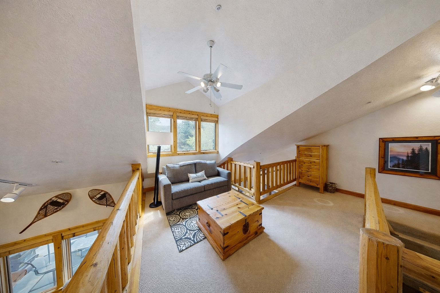 Relax in this cozy loft area with rustic log railings and comfy seating. It's the perfect extra space for reading or unwinding during your mountain getaway.