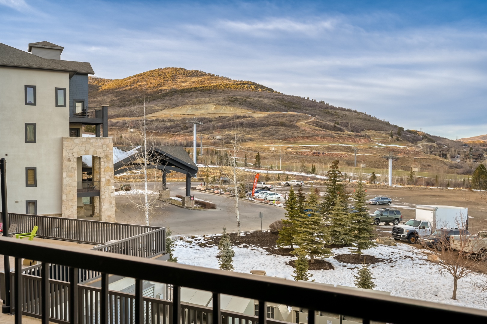 Mountain resort area surrounded by dramatic peaks and winter landscape, with convenient parking and recreational facilities nearby.