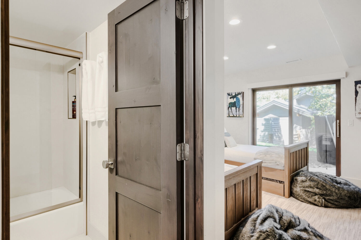 Your cozy bedroom features rustic wood furnishings and a window framing the natural surroundings—ideal for peaceful mornings and restful nights.