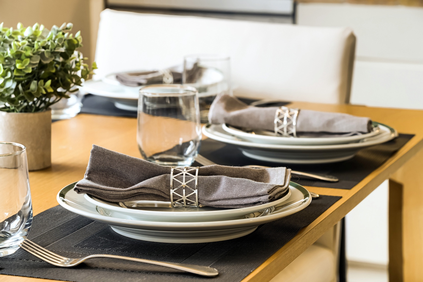 Your stylish dining space awaits with elegant place settings and fresh greenery, making every meal feel special in your home away from home.