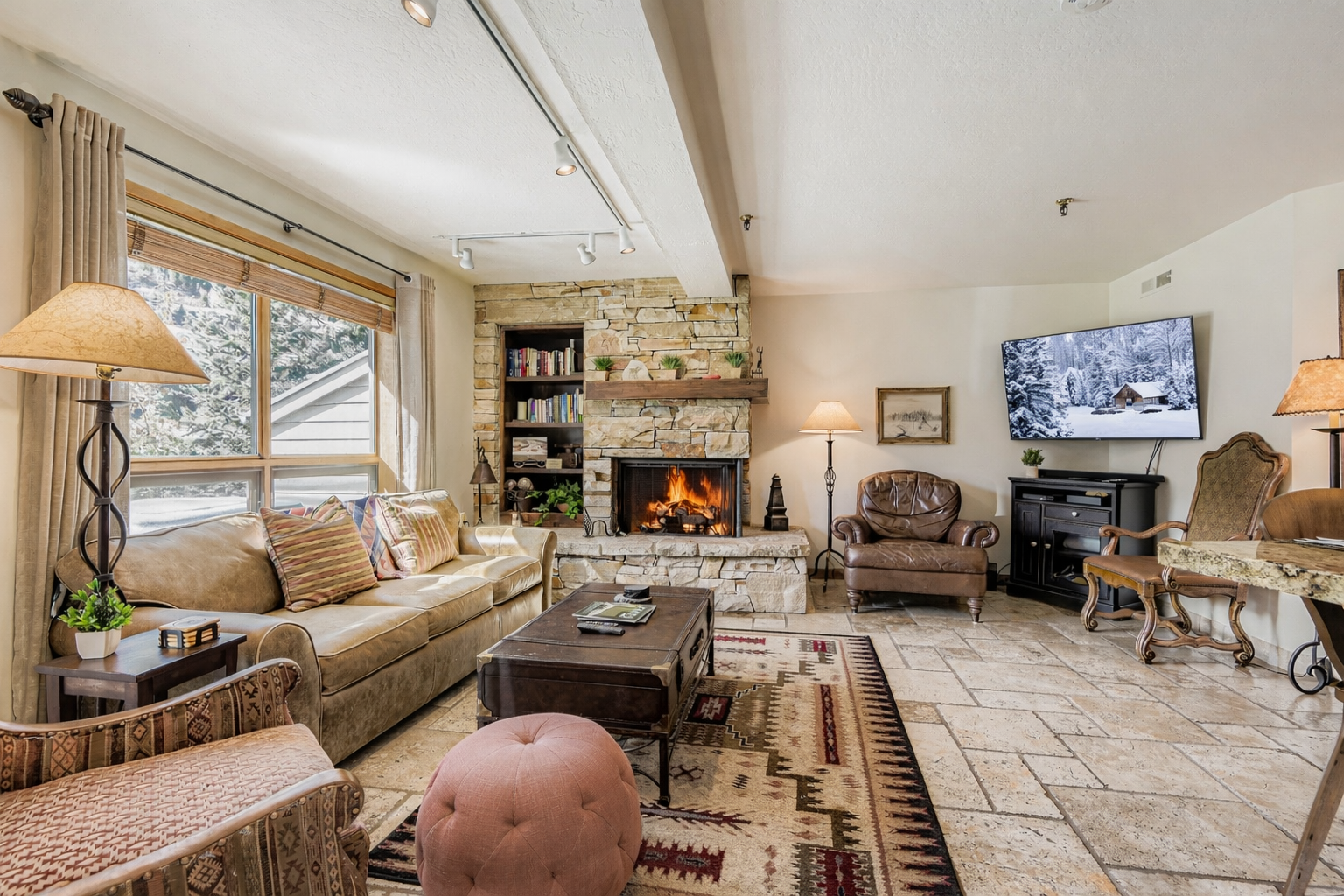 Relax by the stunning stone fireplace after a day outdoors. Watch TV or enjoy the views from the cozy living room.
