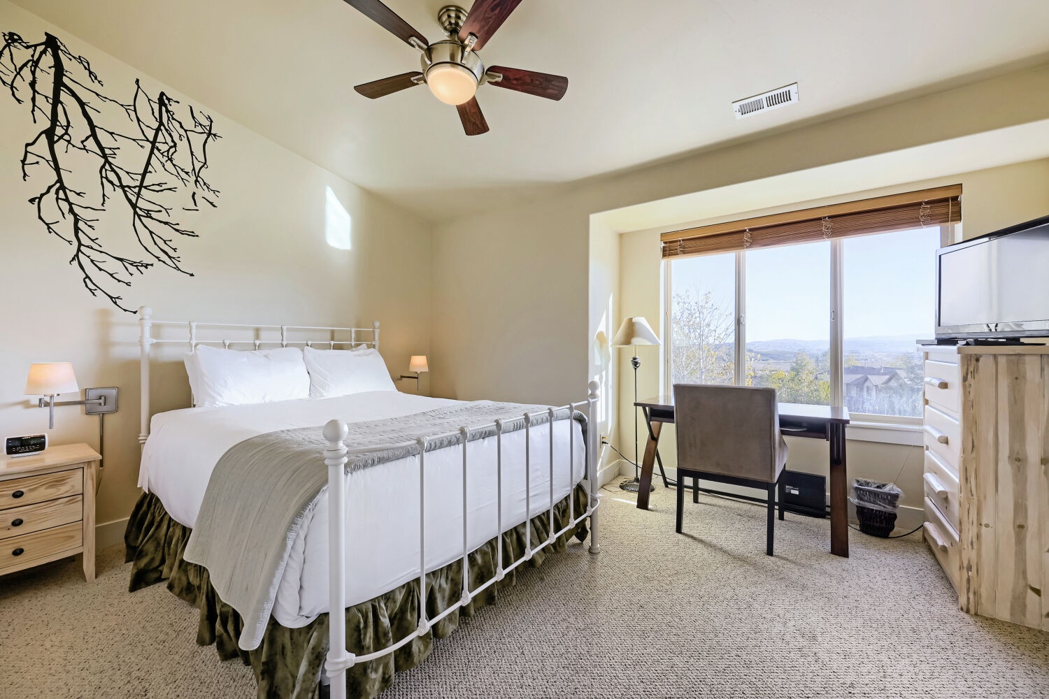 Drift off to sleep in your serene bedroom with mountain views framing the horizon through large windows. Soft linens invite you to unwind beneath a gentle ceiling fan after your mountain adventures.