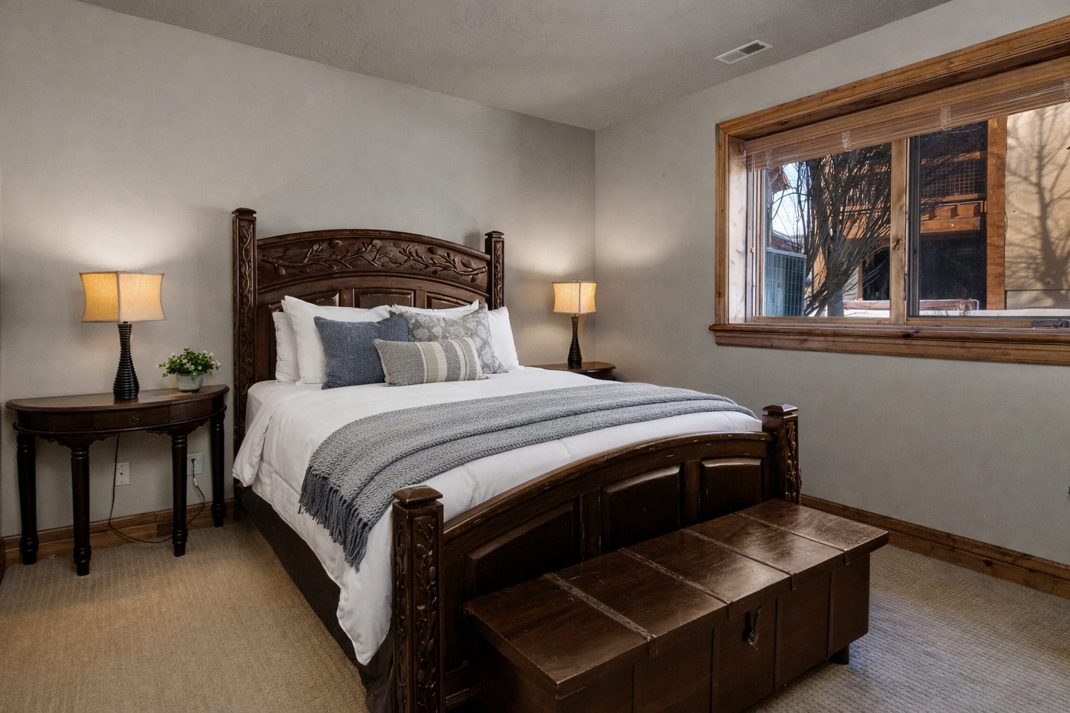 Sink into this cozy bedroom's plush bed after your day of adventure, with soft linens and warm lighting creating the perfect retreat.